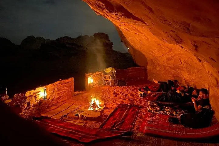 Bedouin cave camp glowing at dusk on a Wadi Rum cave camping jeep tour in Jordan